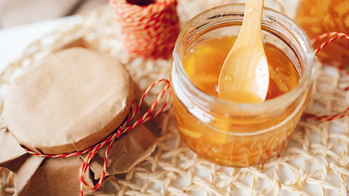 Delicious homemade citrus jam in a jar with a wooden spoon, perfect for breakfast spreads.