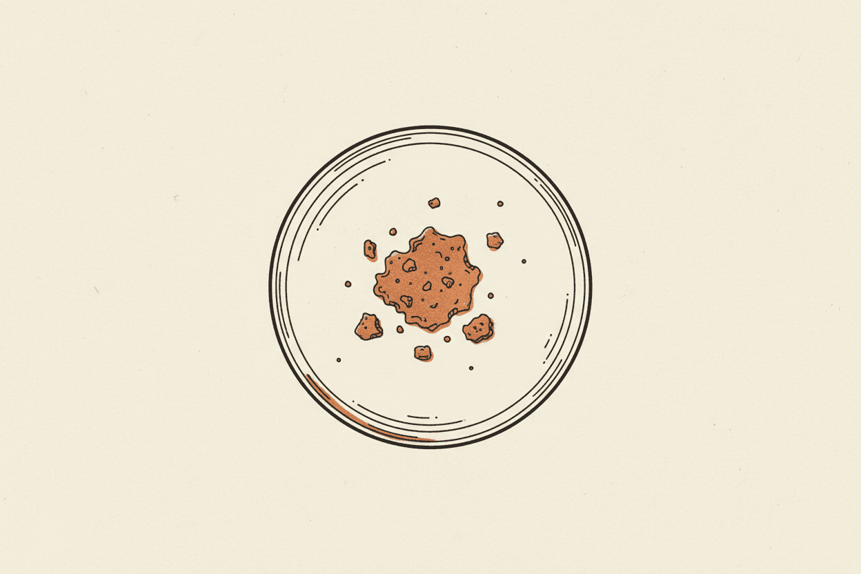 Illustration of a petri dish with a small pile of processed food crumbs